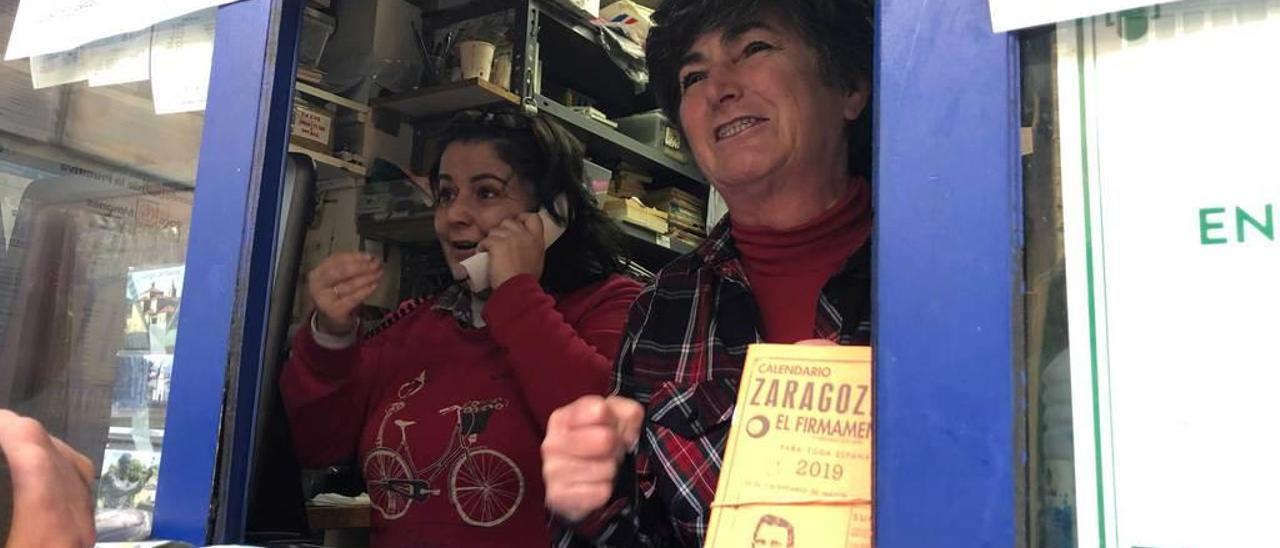 Fátima Fernández y María Dolores Yáñez, ayer, tras la ventanilla del Kiosko de Juan de Cangas del Narcea, en el momento en el que recibieron la noticia de que habían vendido otro premio más del sorteo de Navidad.
