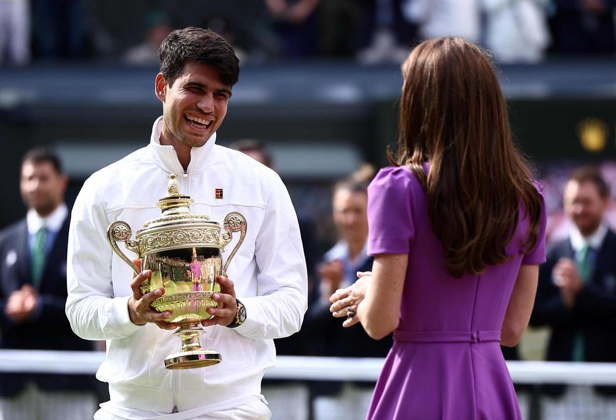 Alcaraz recibe el trofeo de campeón de Wimbledon junto a Kate Middleton.