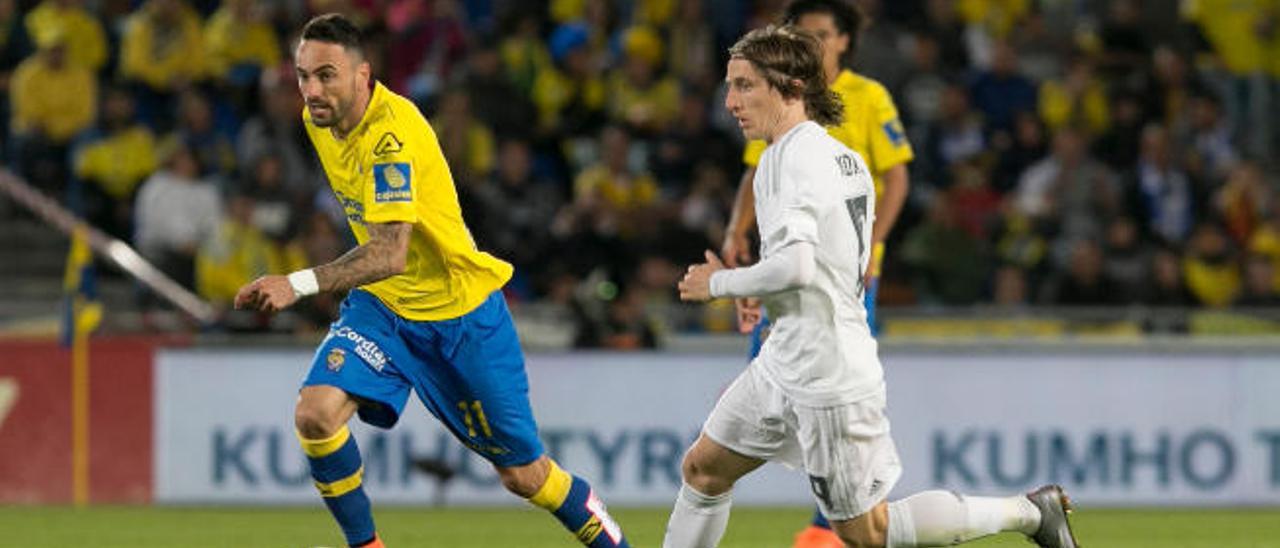Momo controla el balón durante el partido frente al Real Madrid ante la presión de Luka Modric.