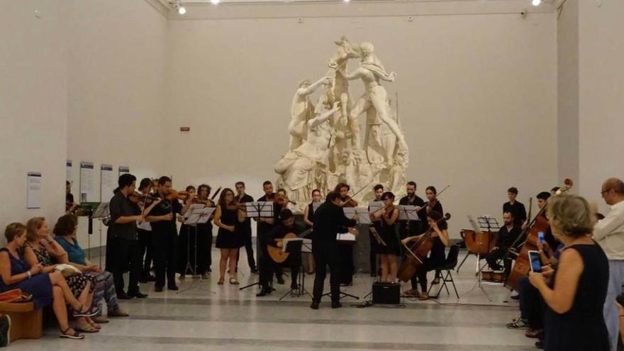 Arriba, la OCAS, tocando delante del monumental &quot;Toro Farnesio&quot;. A la izquierda, el concierto de jazz.