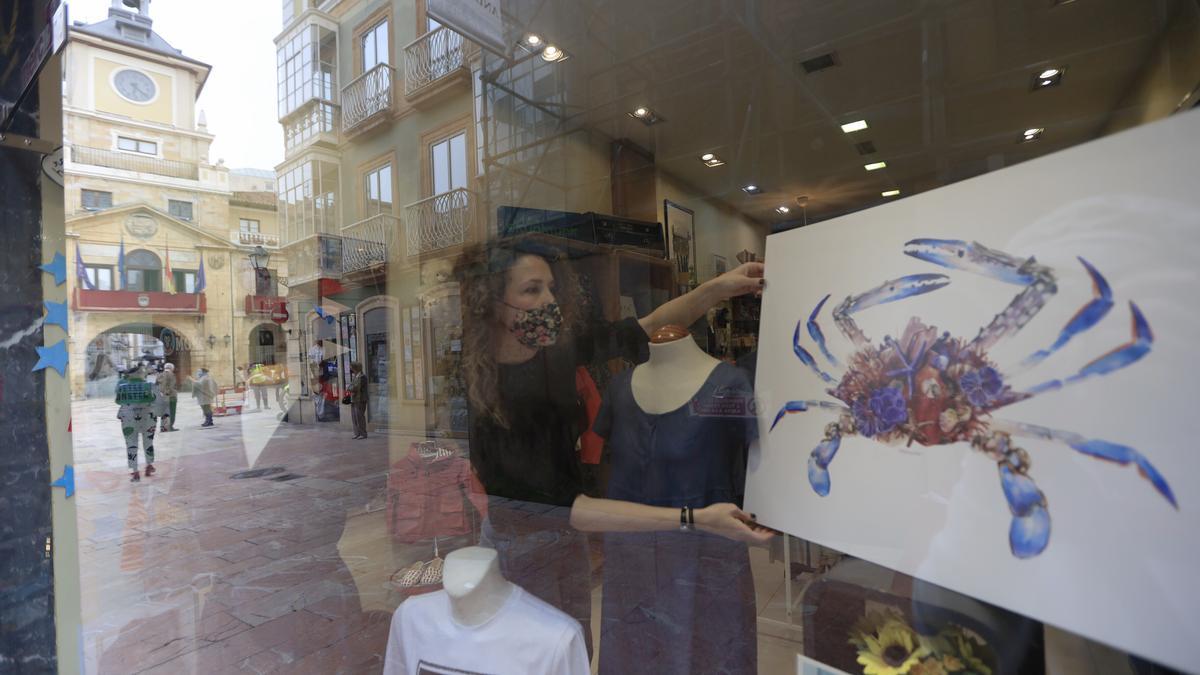 Marina Eiro expone una de sus láminas en un comercio de la calle Magdalena