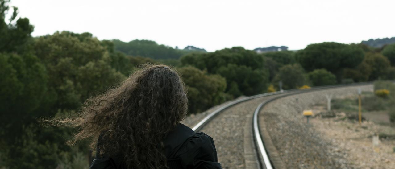 Una mujer contempla las vías del tren, en una imagen alegórica para completar visualmente la información.