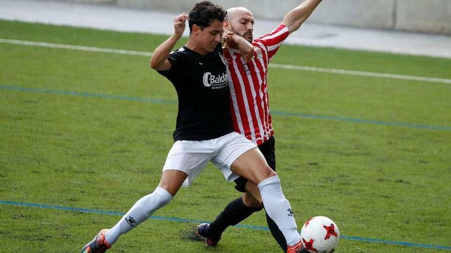 Coutado, a la izquierda, disputa un balón con el sierense Río.