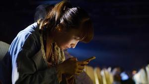ARCHIVOS Esta fotografía de archivo tomada el 27 de abril de 2017 muestra a una mujer usando un teléfono móvil mientras escucha discursos en la Conferencia Global de Internet Móvil GMIC en Beijing Un juego de simulación chino Love and Producer que ha sido descargado más de 10 millones de veces desde su debut en diciembre, principalmente por mujeres que buscan apasionadas aventuras amorosas con sus cuatro pretendientes virtuales.