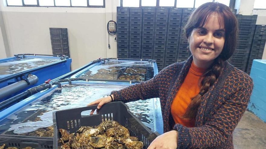 Alejandra Rodríguez, con una de las cajas de ostras que están en depuración.