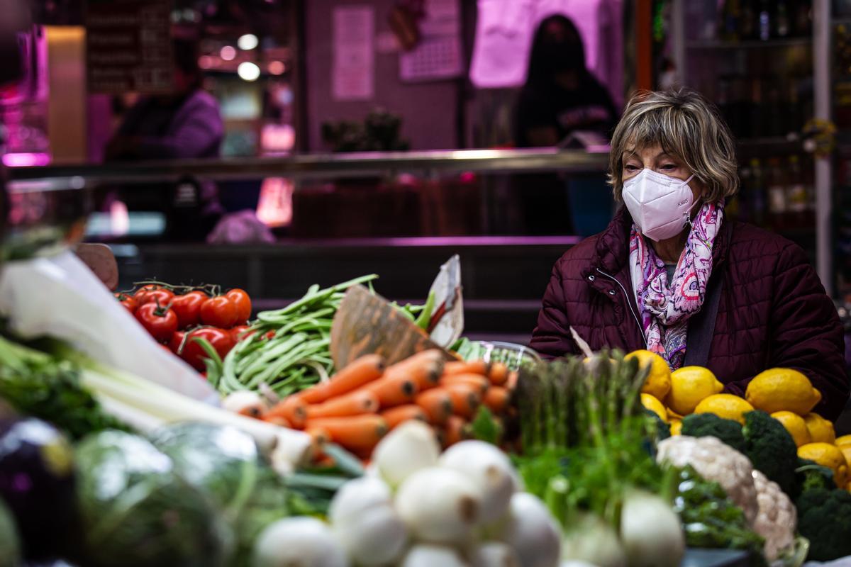 Una clienta observa las verduras del Mercado de Maravillas.