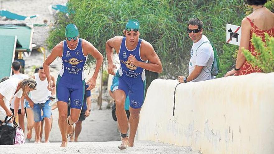 Los líderes ascienden por la escalera de acceso a la playa tras el tramo de natación.