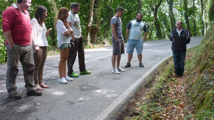 Por la izquierda, César Castaño, Alba Iglesias, Laura Mayo, Alberto Castro, Andrés Garrido, Javi García y Manuel Fernández, en un tramo deteriorado de la carretera AS-219.