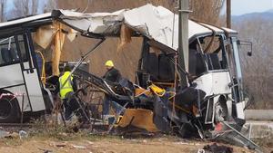 Operarios junto al autobús escolar destrozado por el impacto de la colisión con un tren en Millas, cerca de Perpinyà, el 15 de diciembre.