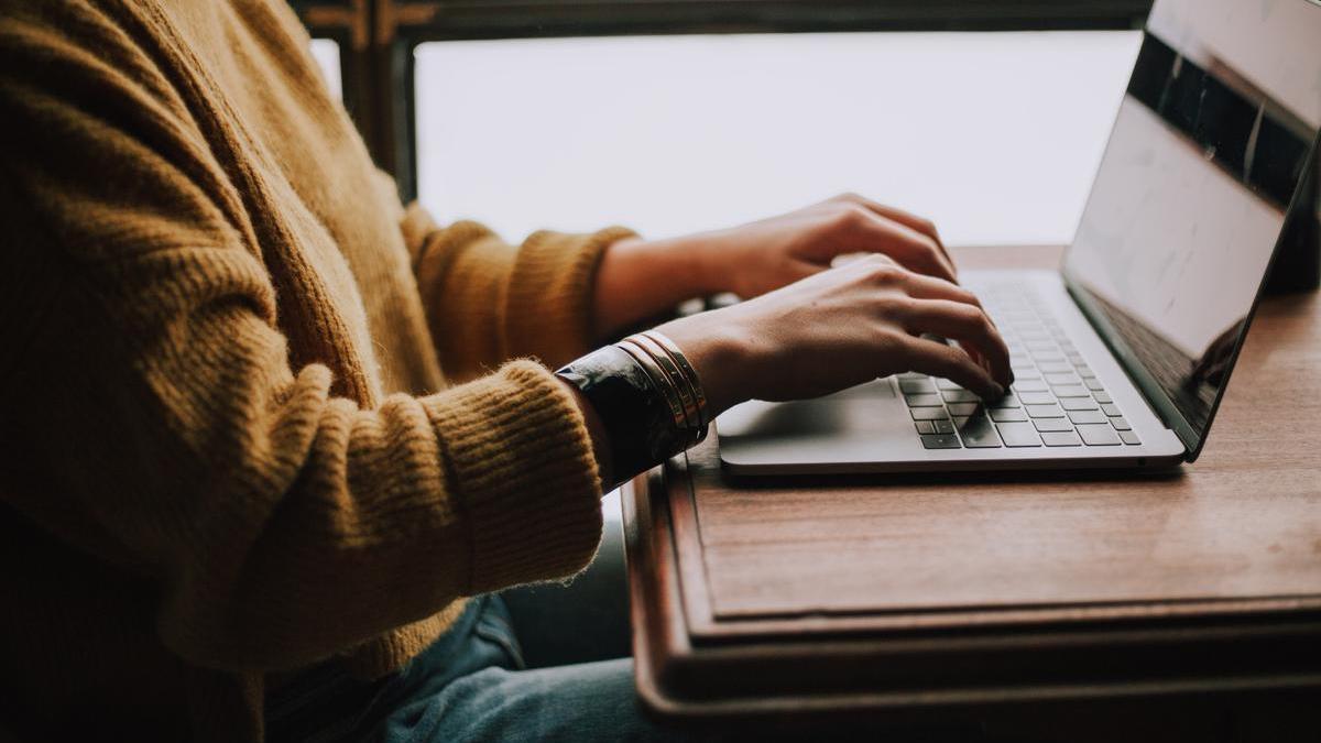 Una mujer realiza una consulta en internet en un ordenador portátil.