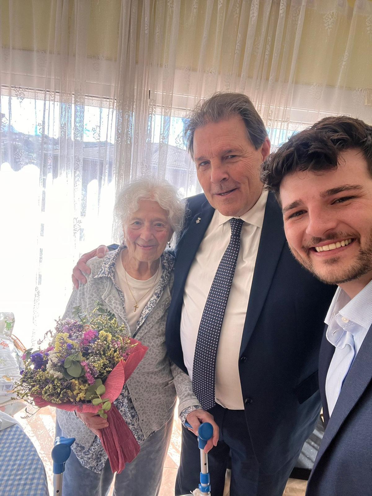 L'alcalde de Castellgalí, Cristòfol Gimeno, lliura un ram de flors a Pilar Arcos Espinosa, que té 101 anys