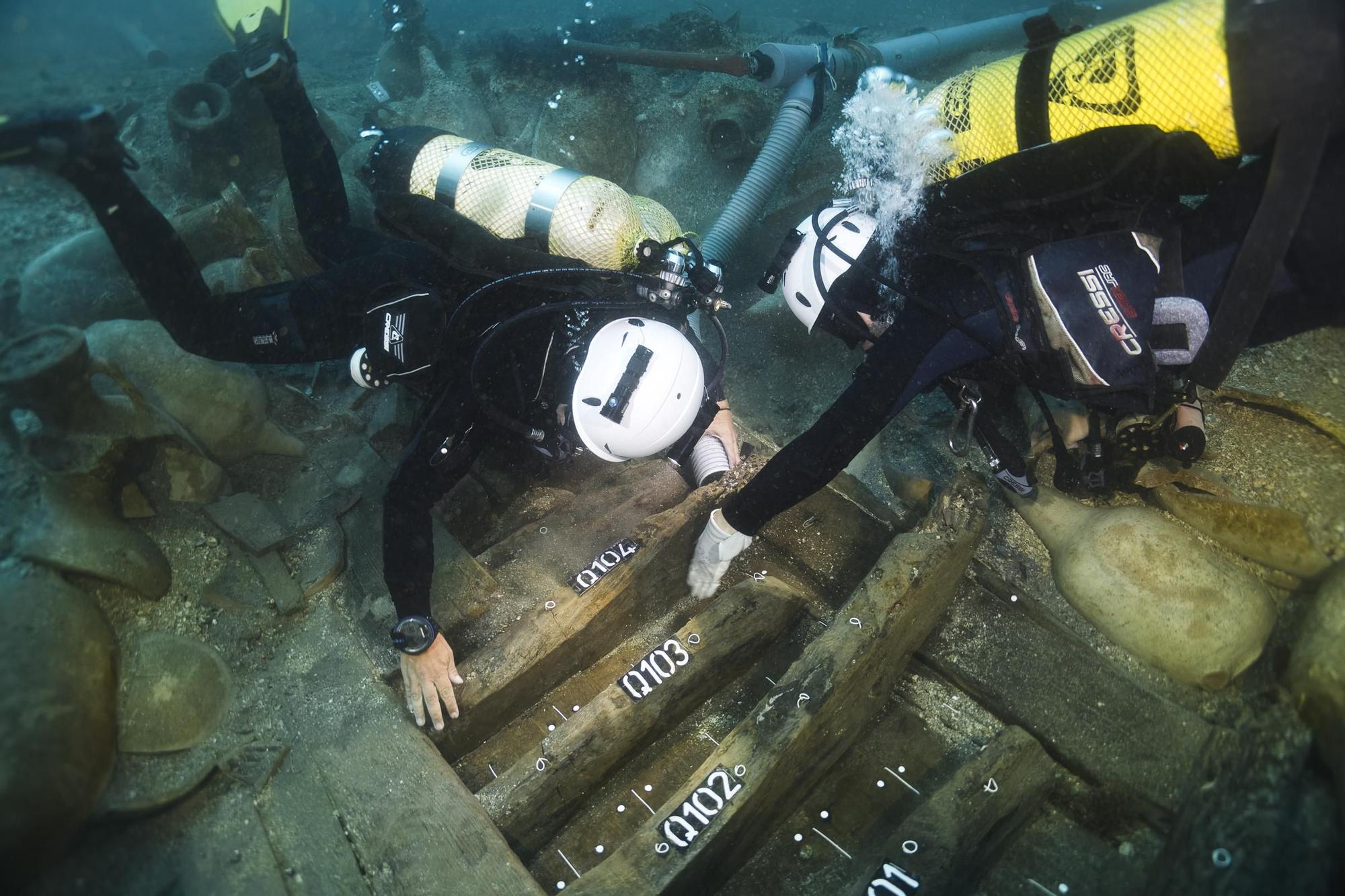 Els arqueòlegs estudiant les fustes del vaixell romà del segle I aC enfonsat durant un temporal a les illes Formigues