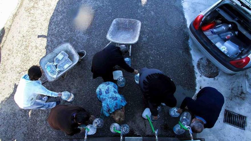 Vecinos de la provincia recogen agua de un camión cisterna a través de garrafas.