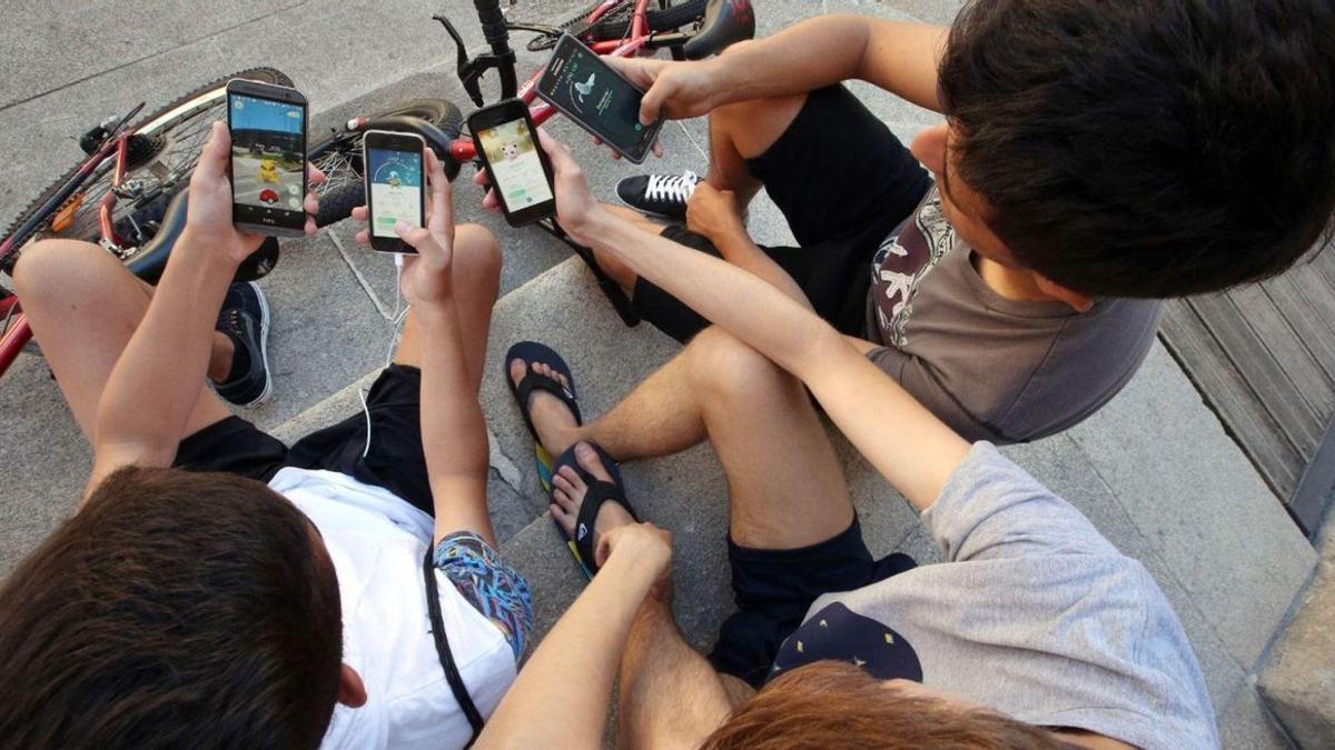 Un grupo de adolescentes pasa el rato jugando con los teléfonos móviles. | MARTA G. BREA / FDV