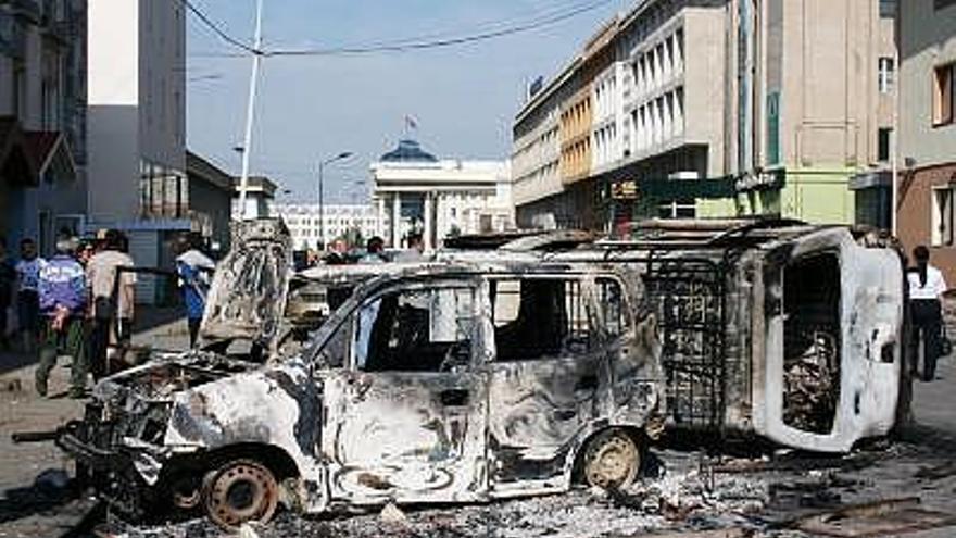 Varios vehículos permanecen destrozados tras las manifestaciones en Ulan Bator.