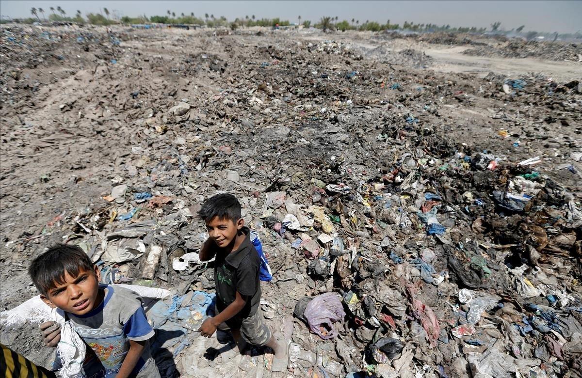 Niños recolectan materiales reciclables en un basurero de Bagdad.