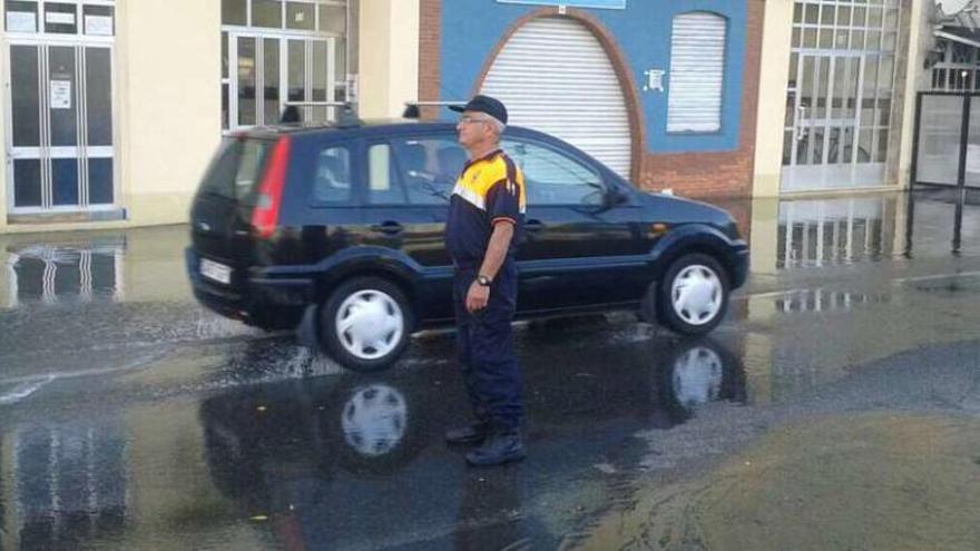 Un efectivo de Protección Civil orientaba ayer el tráfico tras un nuevo desbordamiento en A Ribeira.