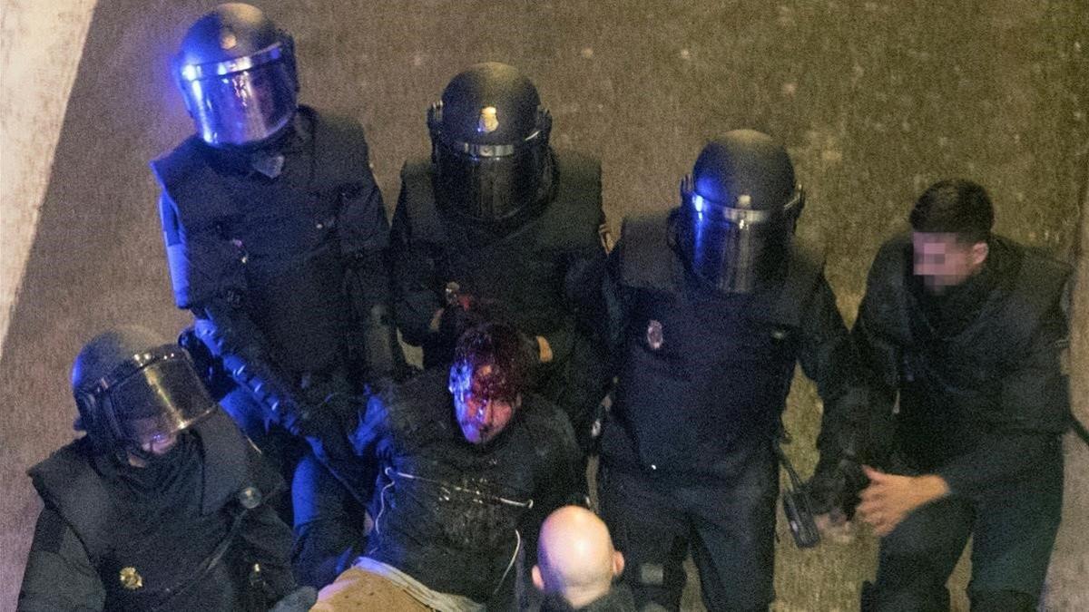 Unos policías detienen a un manifestante durante los altercados producidos en Barcelona la jornada de huelga general, el 18 de octubre del 2019