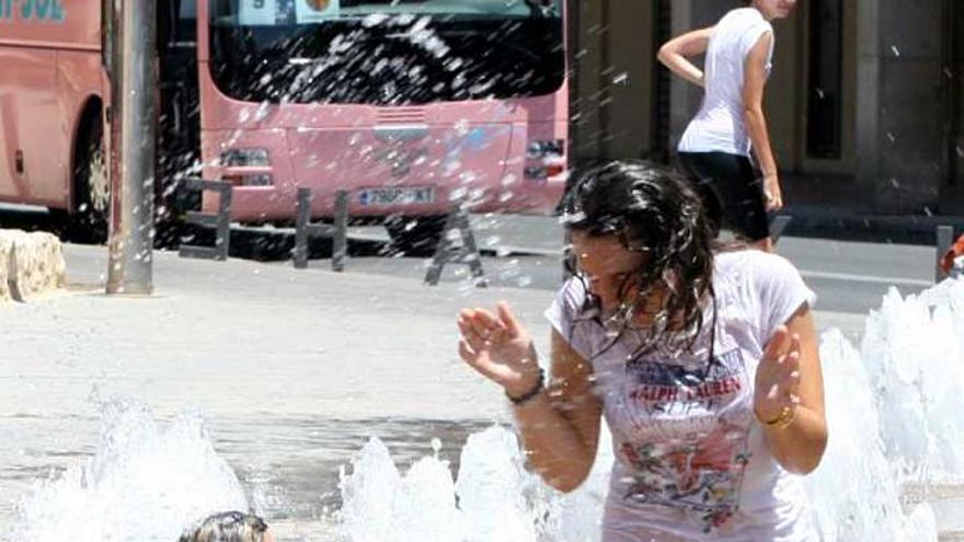 Jóvenes se refrescan en una fuente en los días de calor sofocante