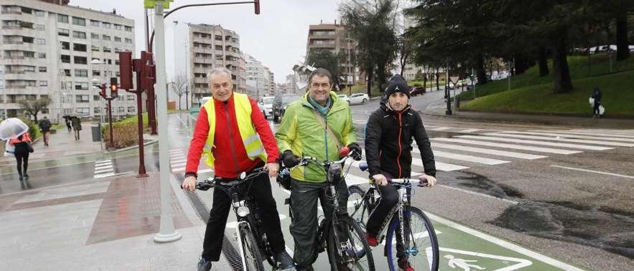 Antonio Montero y José Manuel Suárez, de A Golpe de Pedal, junto a un usuario de la senda verde. // A.V.