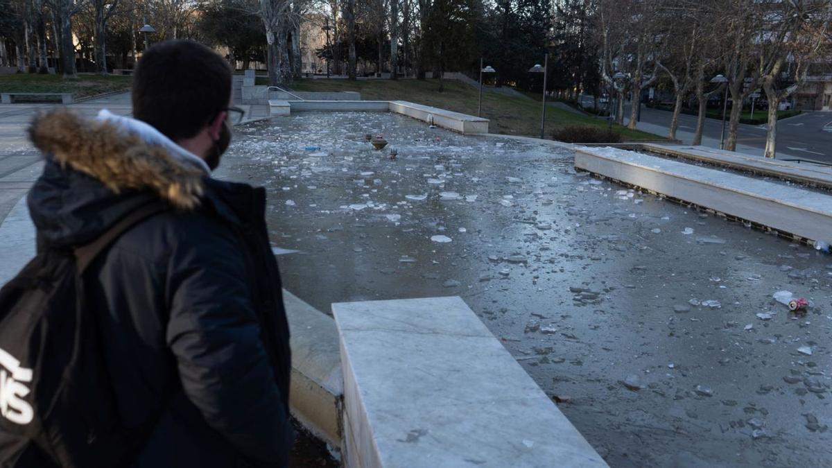 Un zamorano contempla la fuente de La Marina, prácticamente helada.