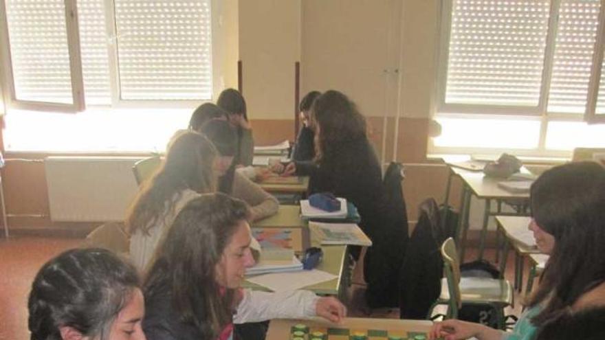 A la izquierda, alumnos del IES Nora, practicando con los juegos de mesa que han construido con materiales reciclados. A la derecha, las profesoras Teresa Cañal y Pilar Hernández posan con el «Proyectu Ñatura».