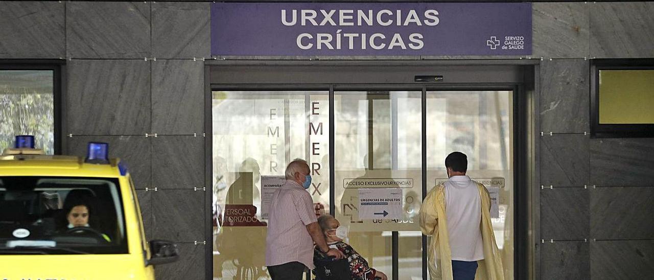Un sanitario y dos pacientes en la puerta de urgencias del Álvaro Cunqueiro de Vigo. |   // R. GROBAS