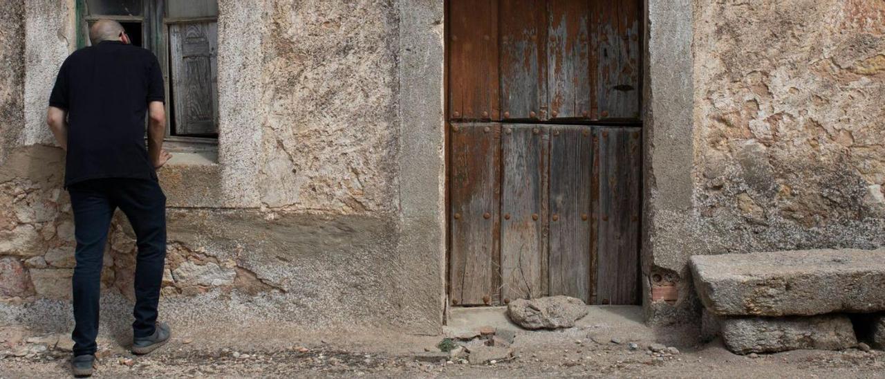 Un hombre se asoma a una casa deshabitada en la provincia de Zamora. |