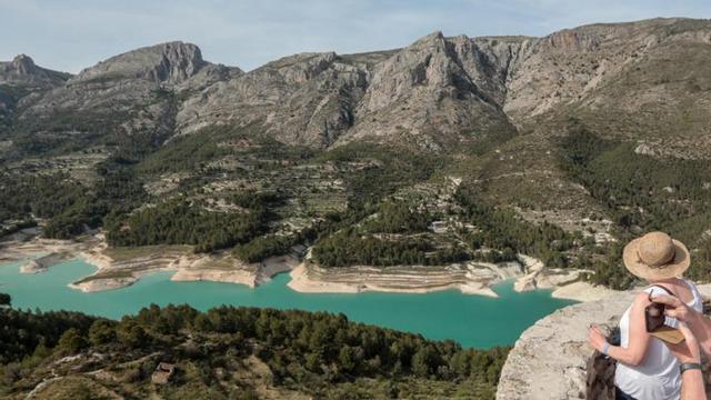 Varios turistas fotografían el embalse de Guadalest.