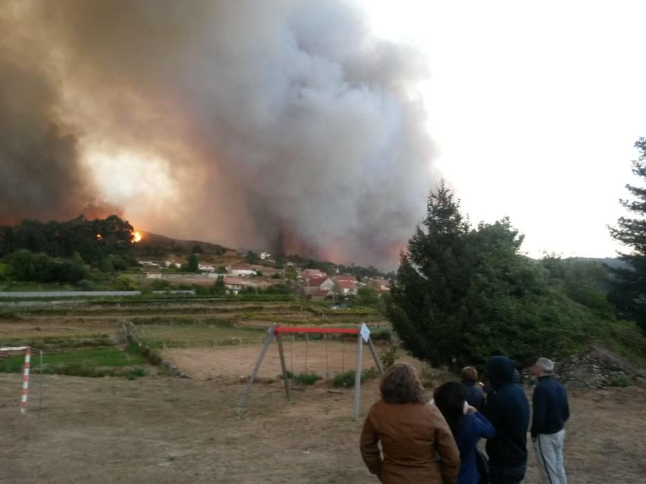 Unos vecinos divisan el incendio en Mondariz. // J. Lores