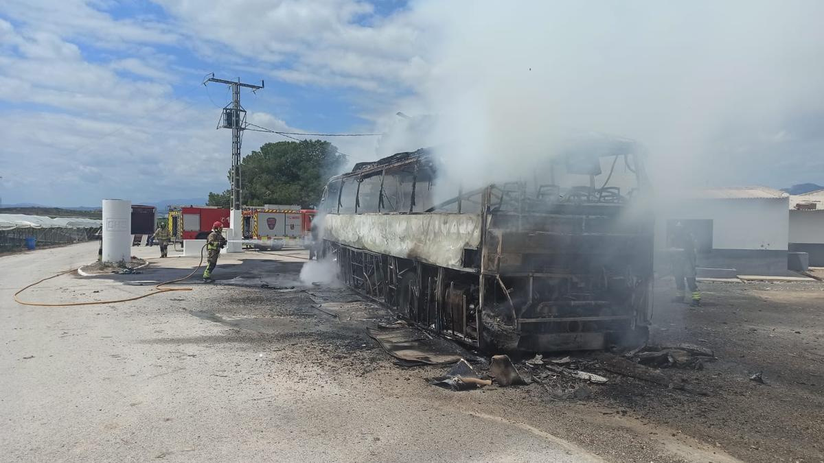 Bomberos sofocan el incendio en un bus en Molina de Segura este viernes.