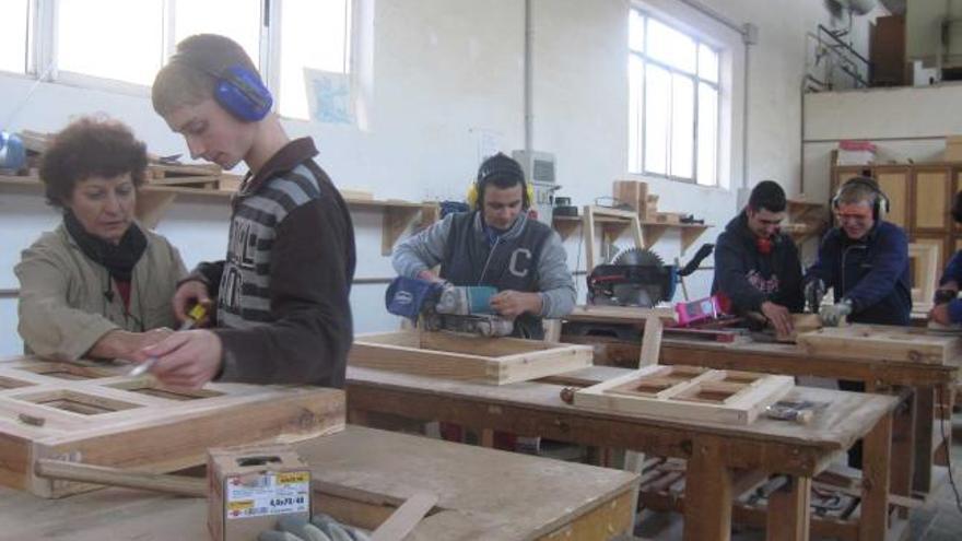 En primer término, la profesora Margarita Llorente da instrucciones al alumno Diego Feito durante una clase del módulo de carpintería. | l. valdés