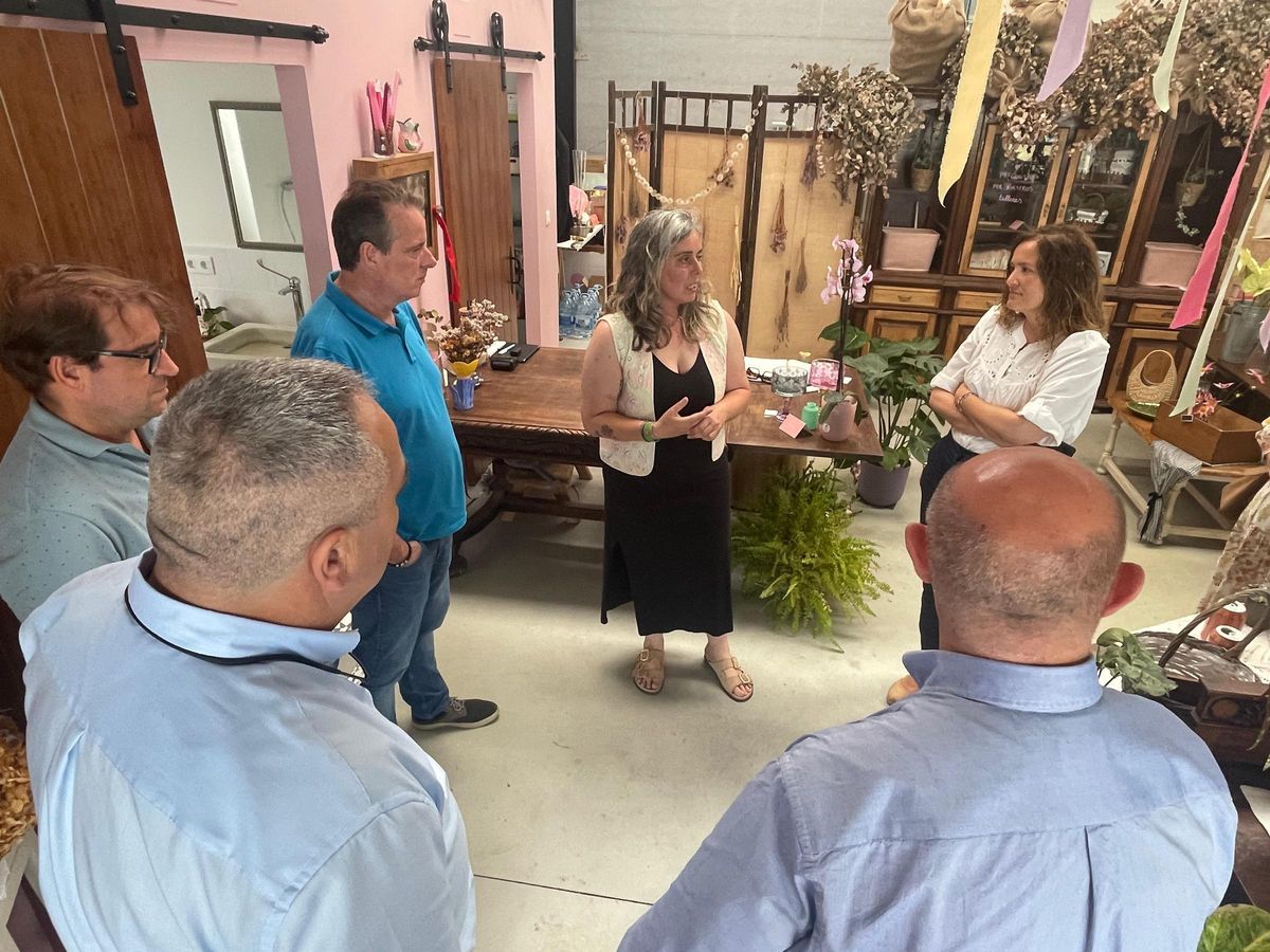 Pamela López, en el centro, explica su negocio a las autoridades, en su nave de Barres (Castropol).