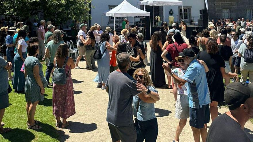 Asistentes bailando en el primer concierto en los jardines.
