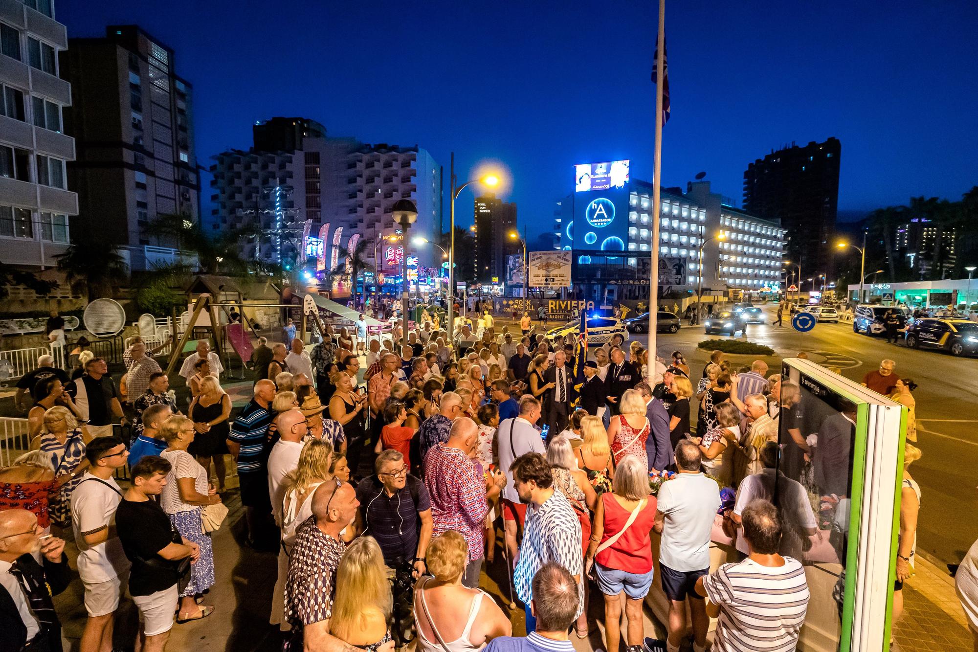 Británicos residentes y turistas de Benidorm rinden un sentido homenaje a Elizabeth II en el espacio habilitado por el Ayuntamiento en la zona inglesa de la ciudad.