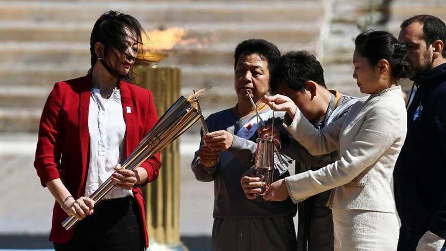 La nadadora Naoko Imoto recibe el fuego que se llevarán a Japón. // Reuters