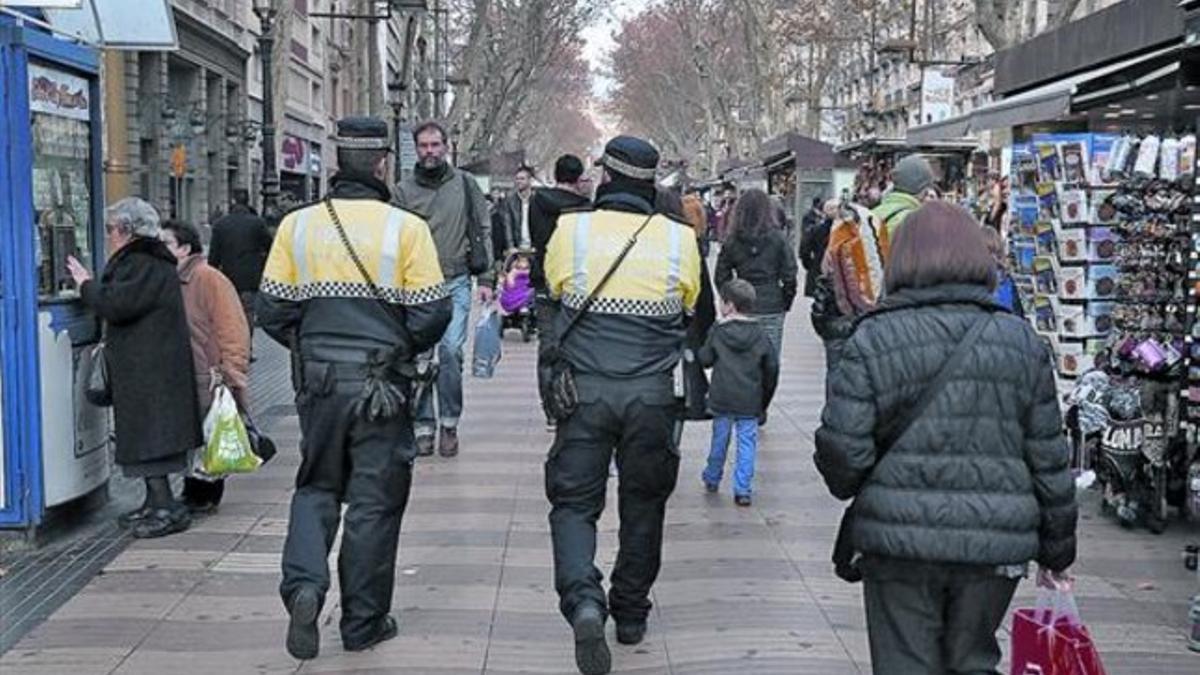 Dos agentes de la Guardia Urbana patrullan por la Rambla, el martes.