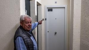 Un vecino muestra una de las puertas de acceso a uno de los apartamentos ya terminados de la calle Tarragona, 84.