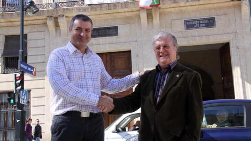 Juan Ponsoda y Paco Aznar se felicitan mutuamente ante el edificio del Ayuntamiento.