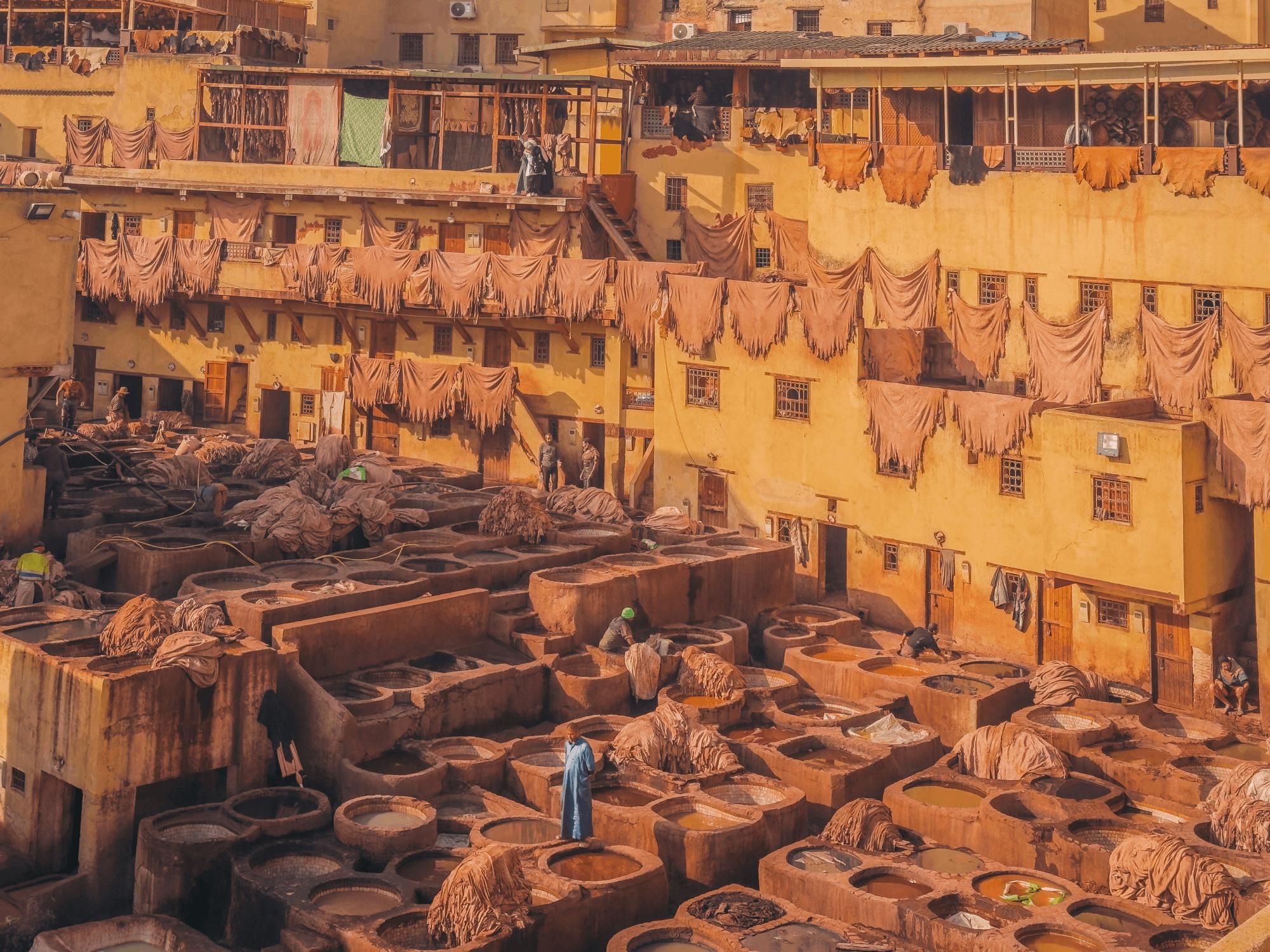 Fez, Marruecos. Un trabajador cruza entre los tanques de tinte de la curtiembre Chouara, en funcionamiento desde al menos el siglo XVI. El proceso de curtido, con una mezcla de cal, sal y orina de vaca, apenas cambió en cientos de años. (iPhone 16 Pro Max)