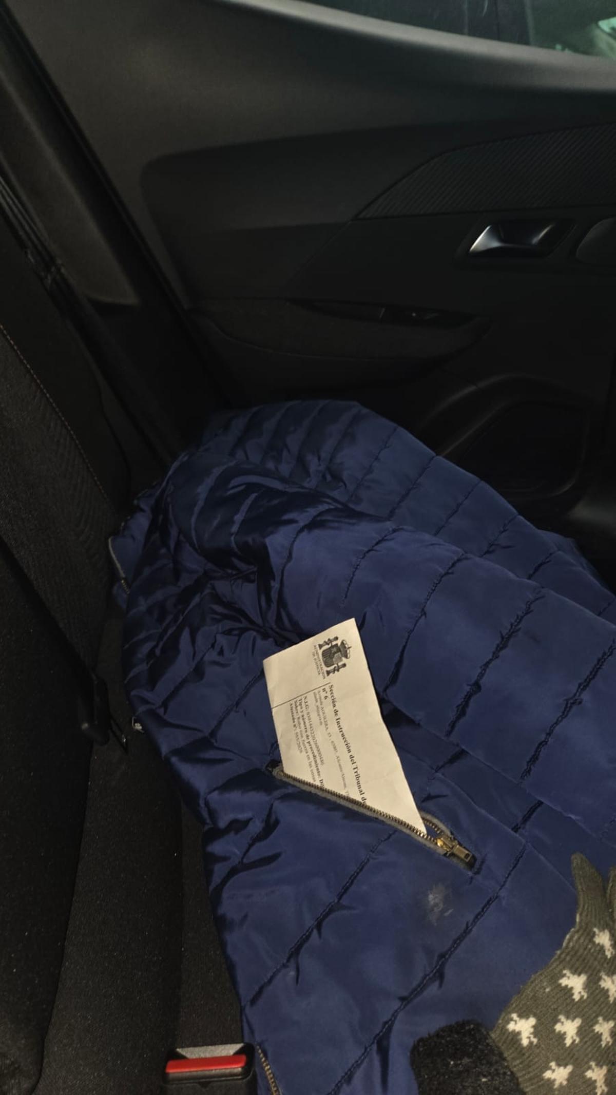 Chaqueta y auto de libertad que olvidó el detenido en un coche forzado.