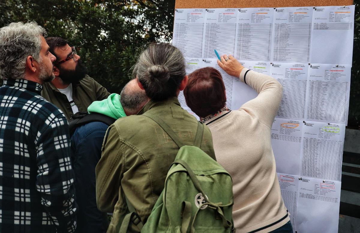 Unos opositores se buscan en las listas.