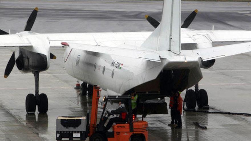 Un operario descarga un palé de un avión en Peinador