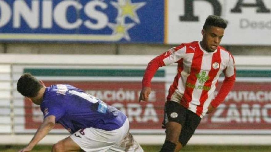 Raly conduce el balón ante un rival.