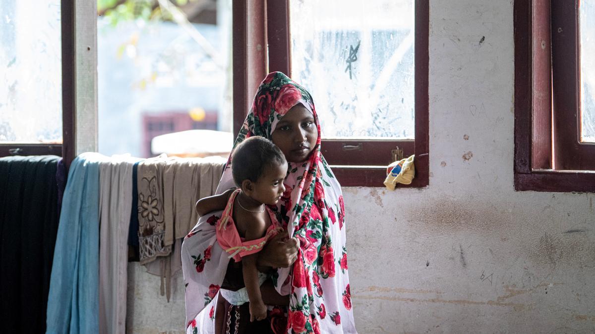 Una mujer lleva a un niño a un refugio temporal en Sumatra.