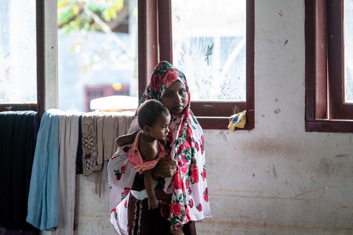 Una mujer refugiada lleva a un niño a un refugio temporal en Pidie, Sumatra.