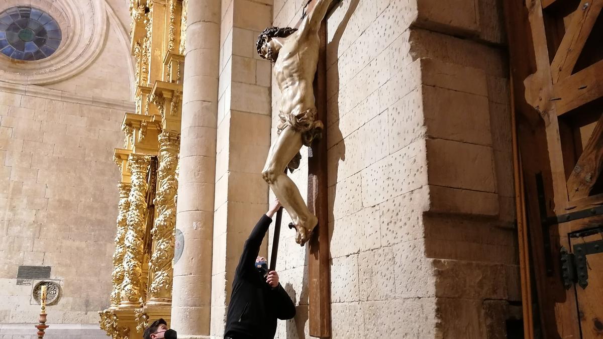 Un cofrade fija la imagen del Cristo del Amparo tras su traslado provisional a la Colegiata