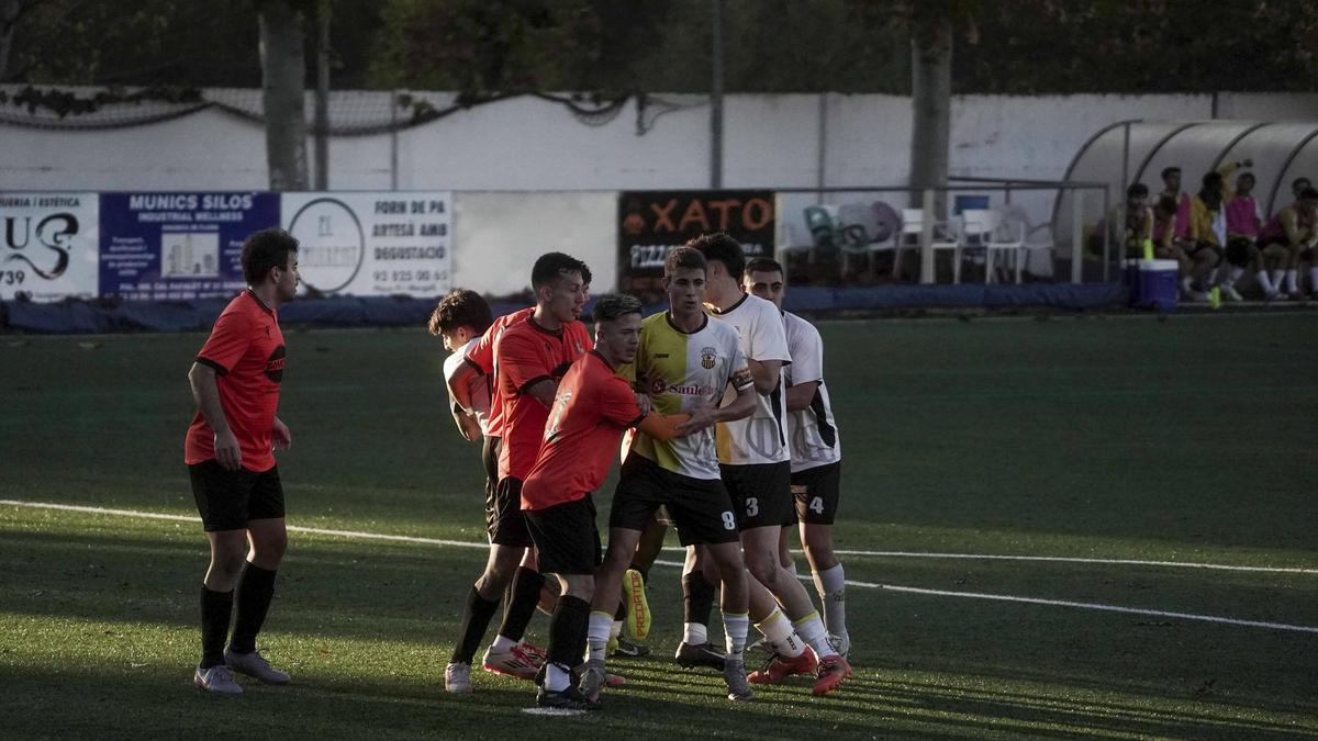 Jugadors d'ambdós equips es preparen per una centrada a l'àrea