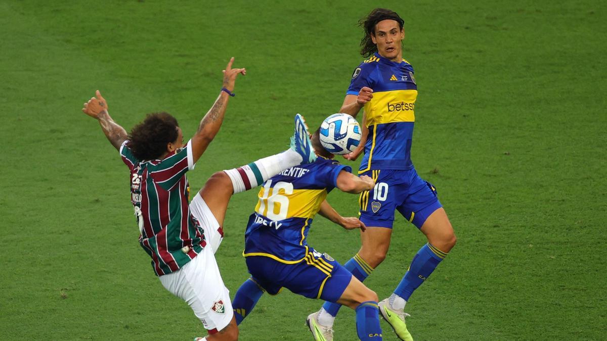 Marcelo, del Fluminense levanta la pierna ante Merentiel y Cavani, del Boca.