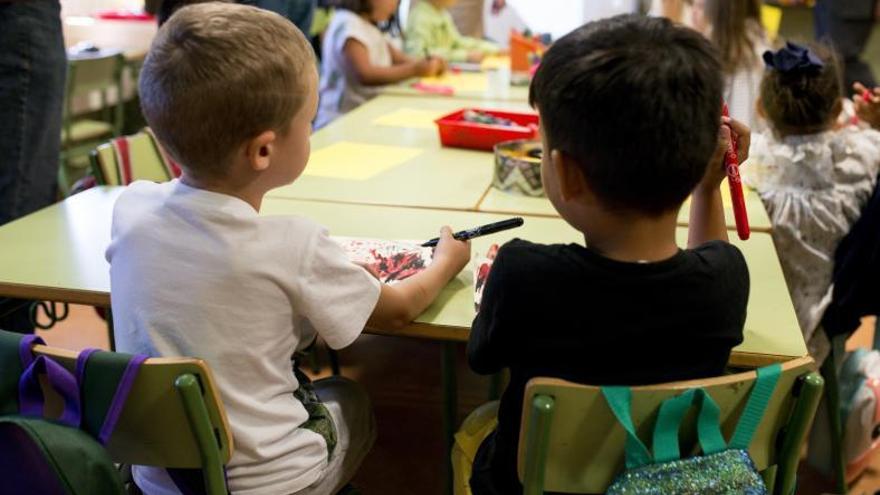 Dos niños atienden durante una clase en el colegio